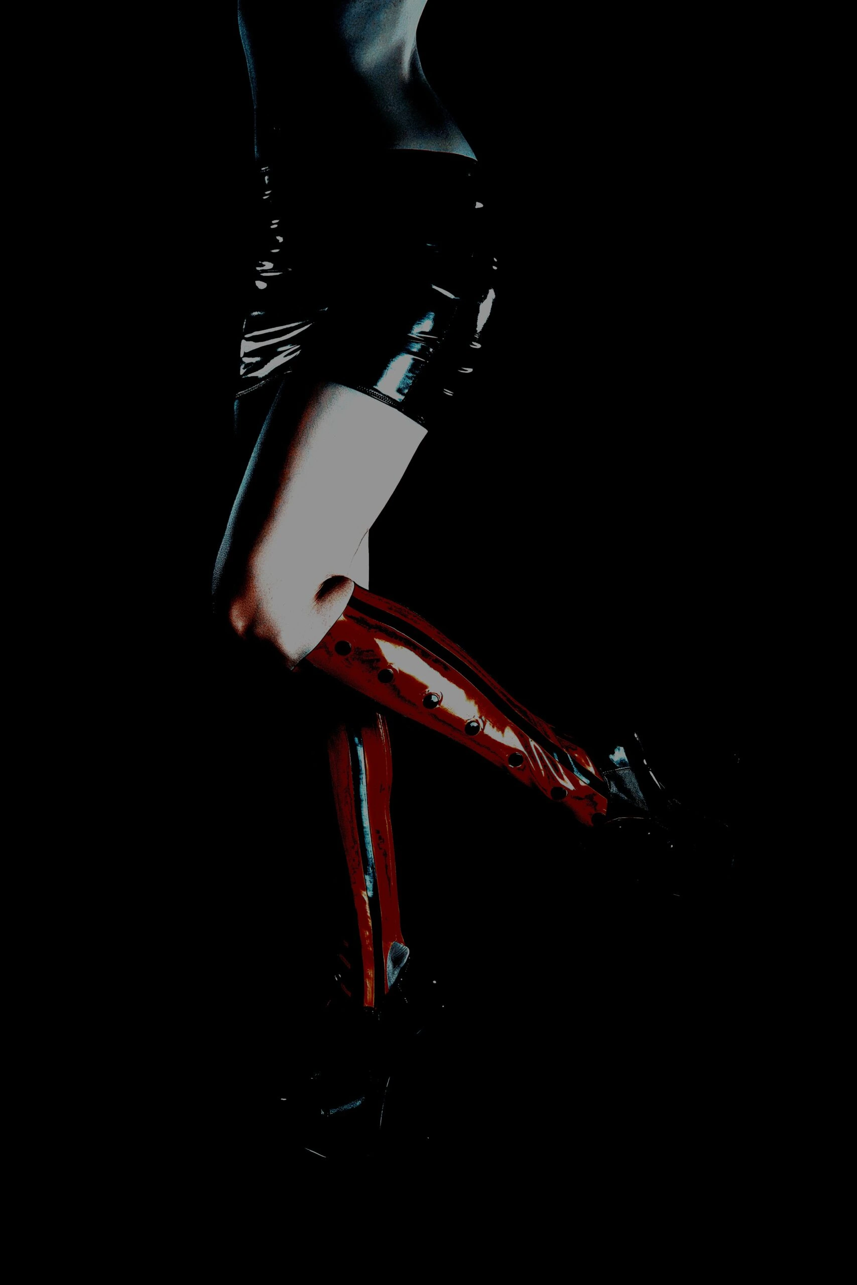 Moody silhouette of person in high heels and glossy outfit with dramatic contrast lighting
